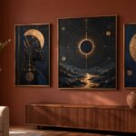 A modern living room corner with a three-piece Afrofuturist gallery wall in bronze frames against a deep clay-toned wall, soft daylight, a low sideboard, and a single terracotta vase
