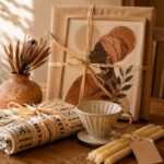 A curated housewarming gift arrangement of afrocentric housewarming gifts — framed portrait, clay vessel, mudcloth throw, brass pour-over