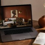 AI prompts for afrocentric room mockups — laptop showing generated interior next to notebook and brass cup