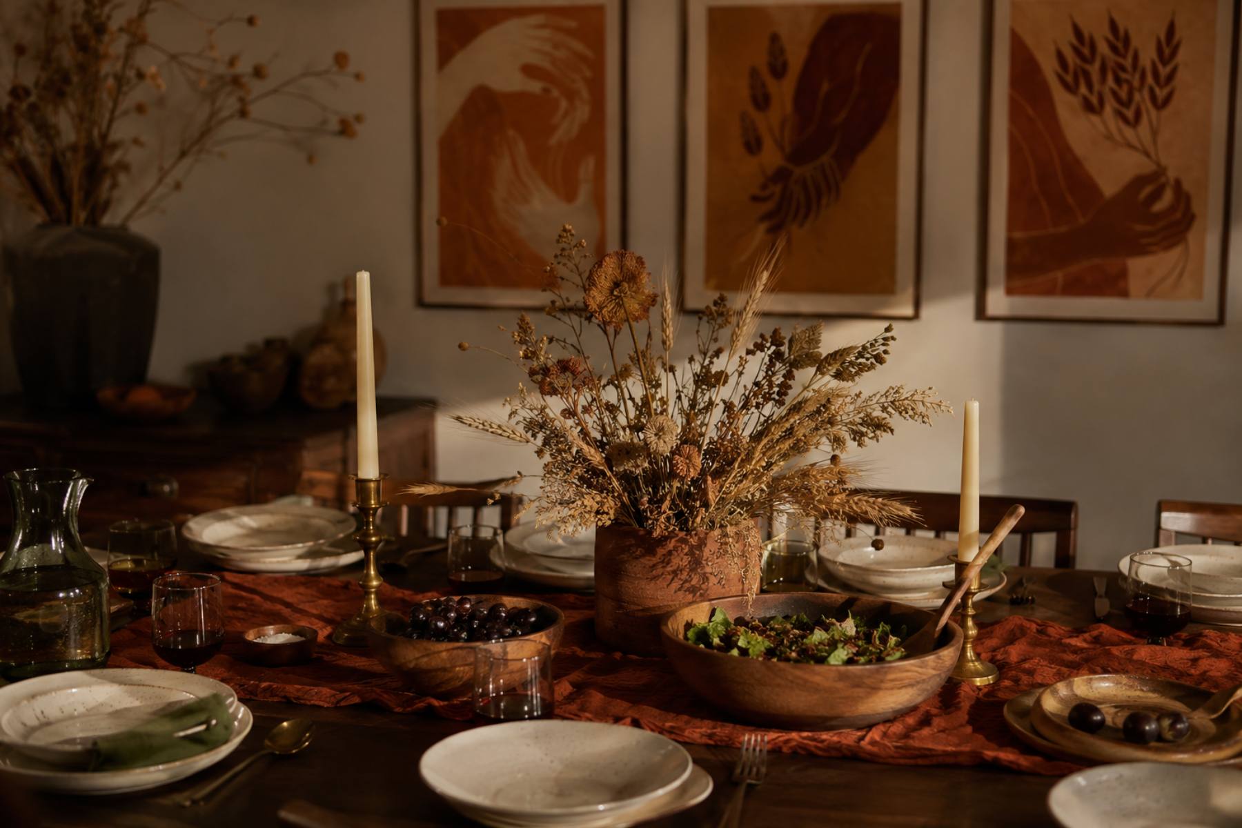 Black Thanksgiving decor: a rust and clay harvest table with dried grains and Afrocentric gratitude wall art behind